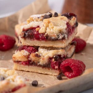 Raspberry chocolate bars stacked on top of each other showing the jam and chocolate.