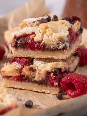 Raspberry chocolate bars stacked on top of each other showing the jam and chocolate.