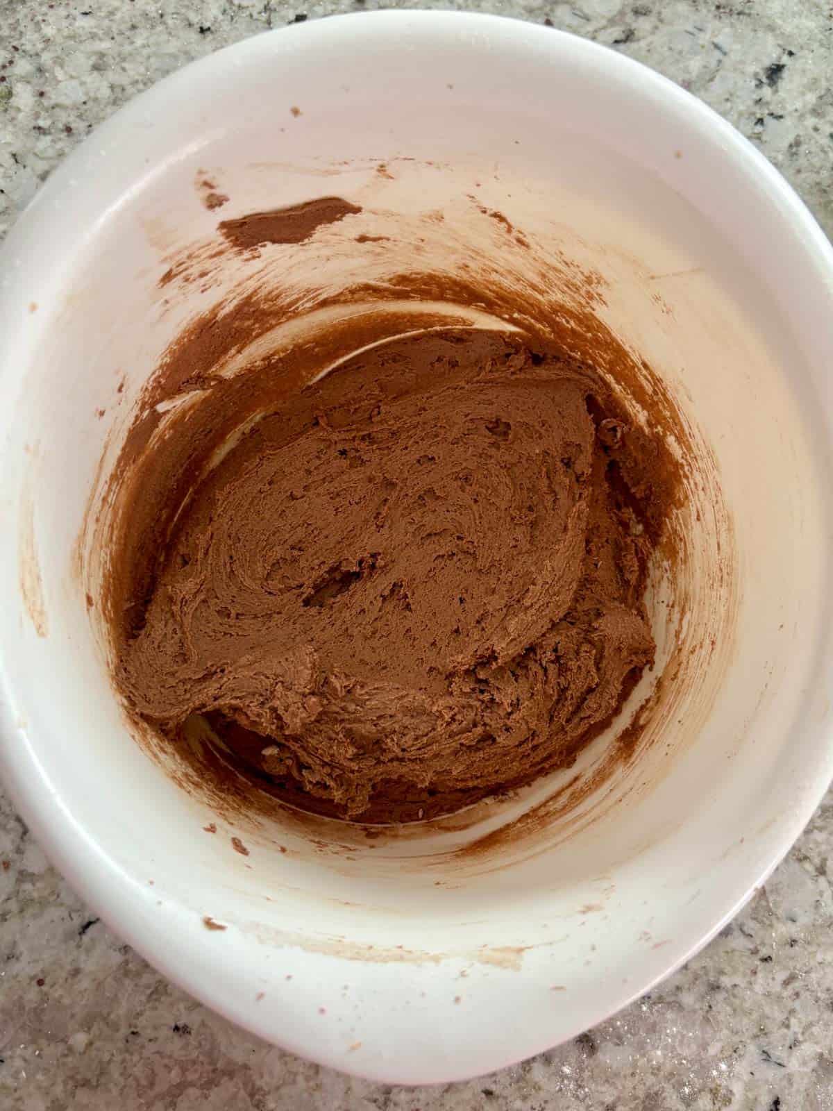 The all purpose flour, salt, baking soda, and cocoa powder being added to the bowl.