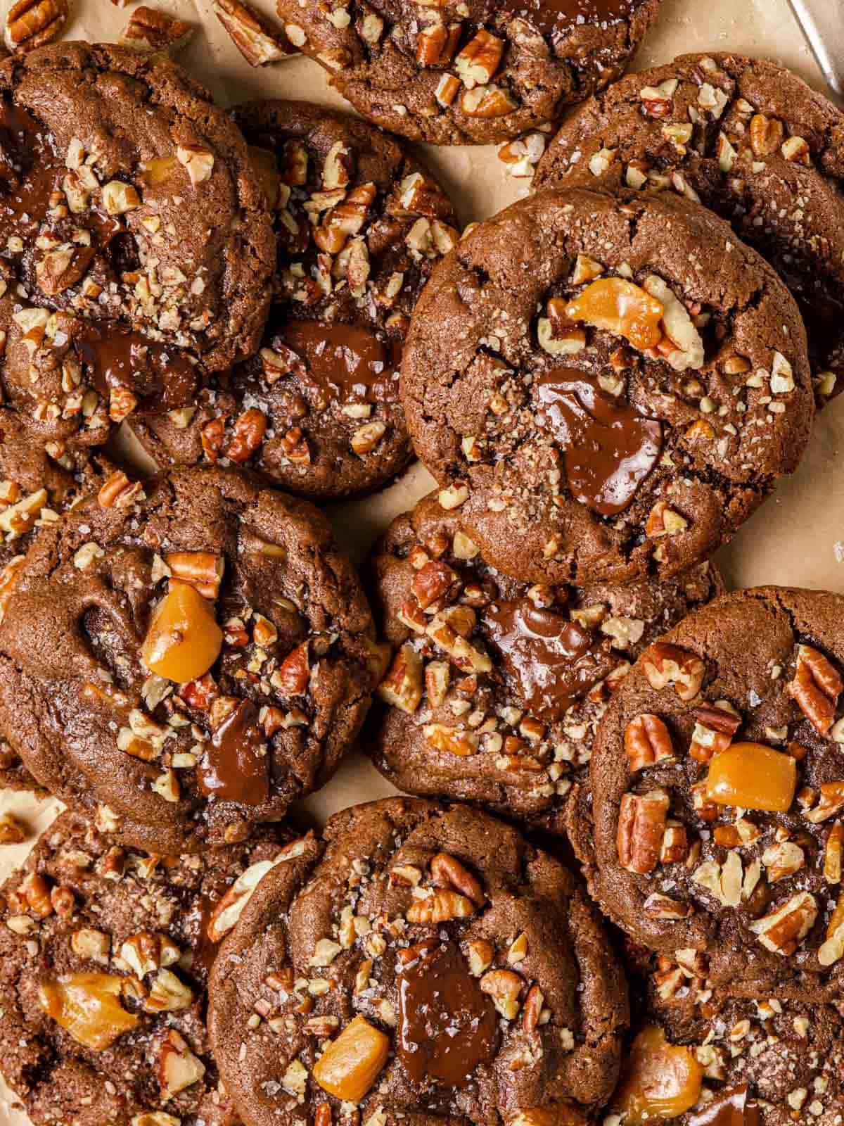 Chocolate cookies with soft caramels and toasted pecans on top.