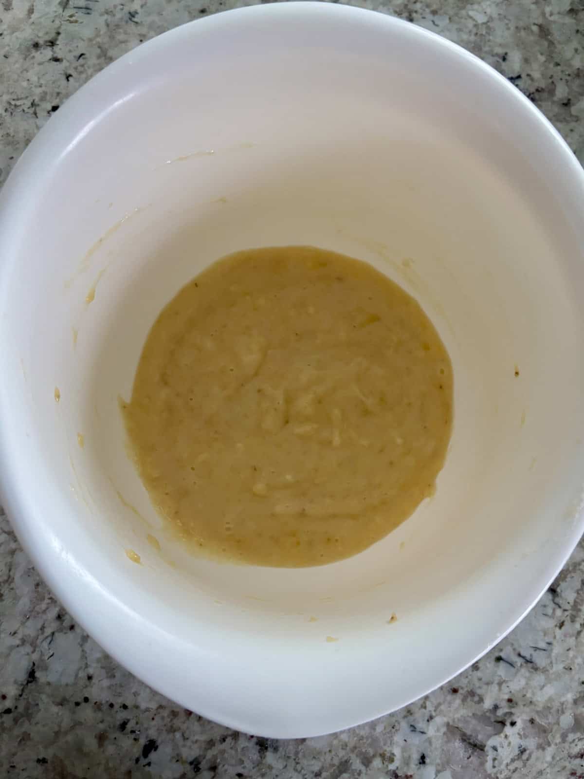 Mashed banana in a bowl on the counter.