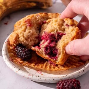 Showing the inside of a banana and blackberry muffins moist and fluffy texture.