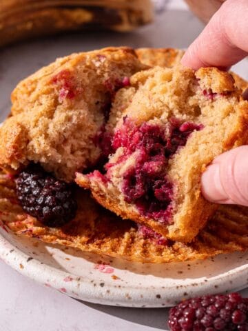 Showing the inside of a banana and blackberry muffins moist and fluffy texture.