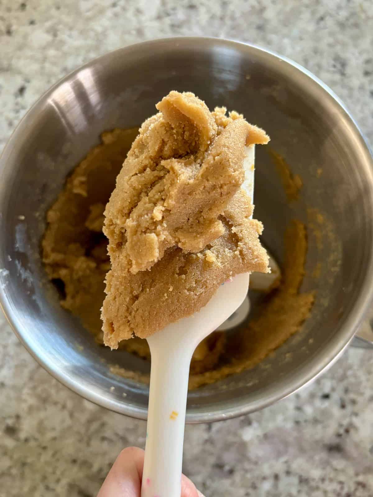 Creamed butter, granulated sugar, and dark brown sugar on a spatula.