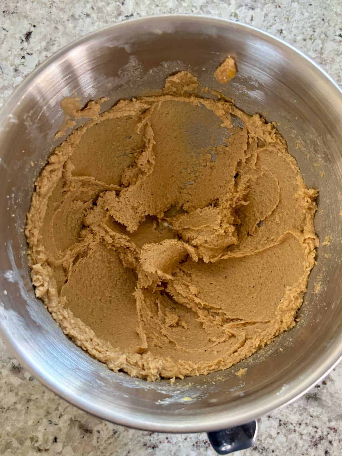 The butter sugar mixture in a mixing bowl after the egg and egg yolk, and vanilla was added.