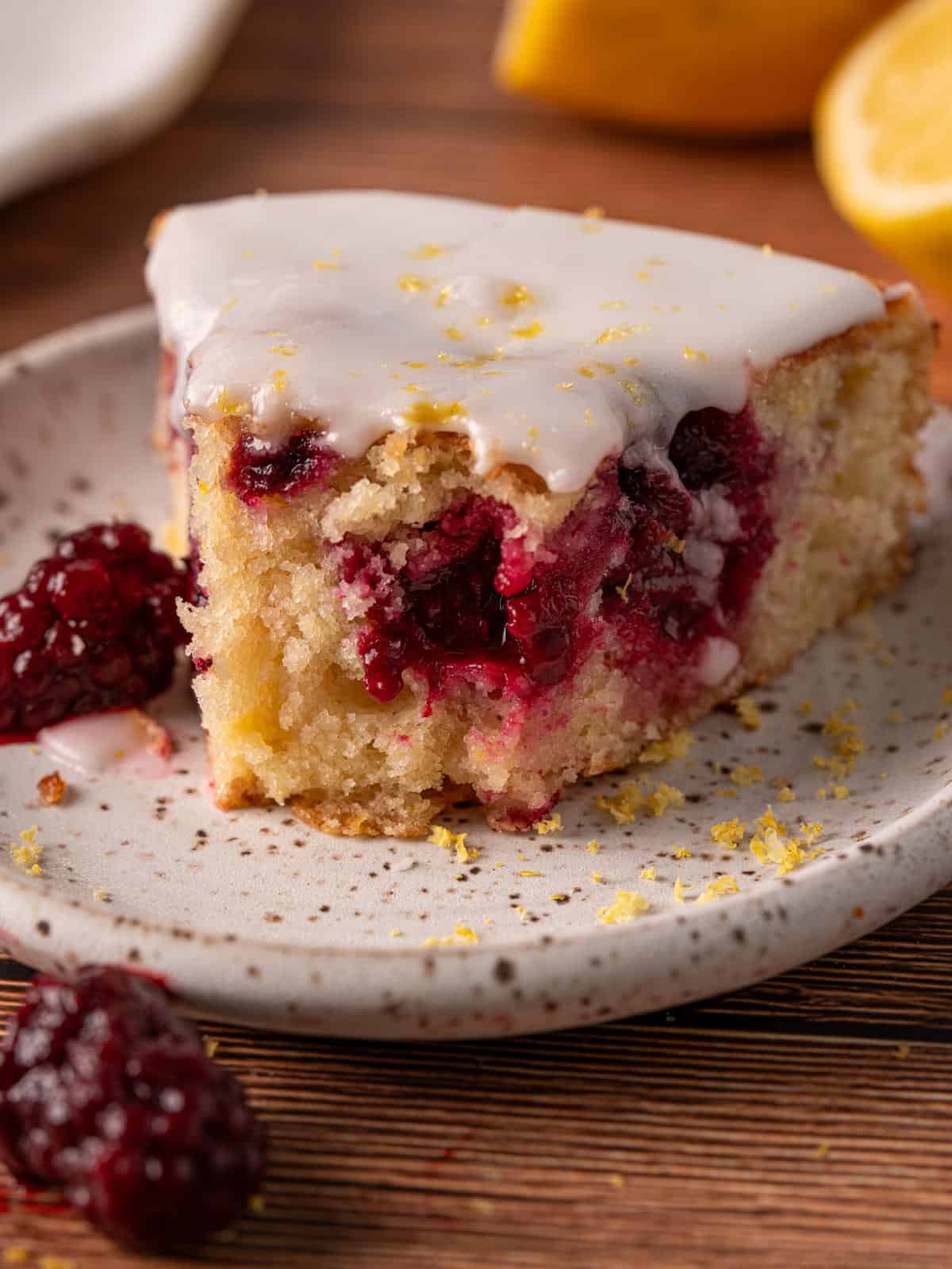 A slice of cake with fresh lemon juice icing on top with a bite taken out.