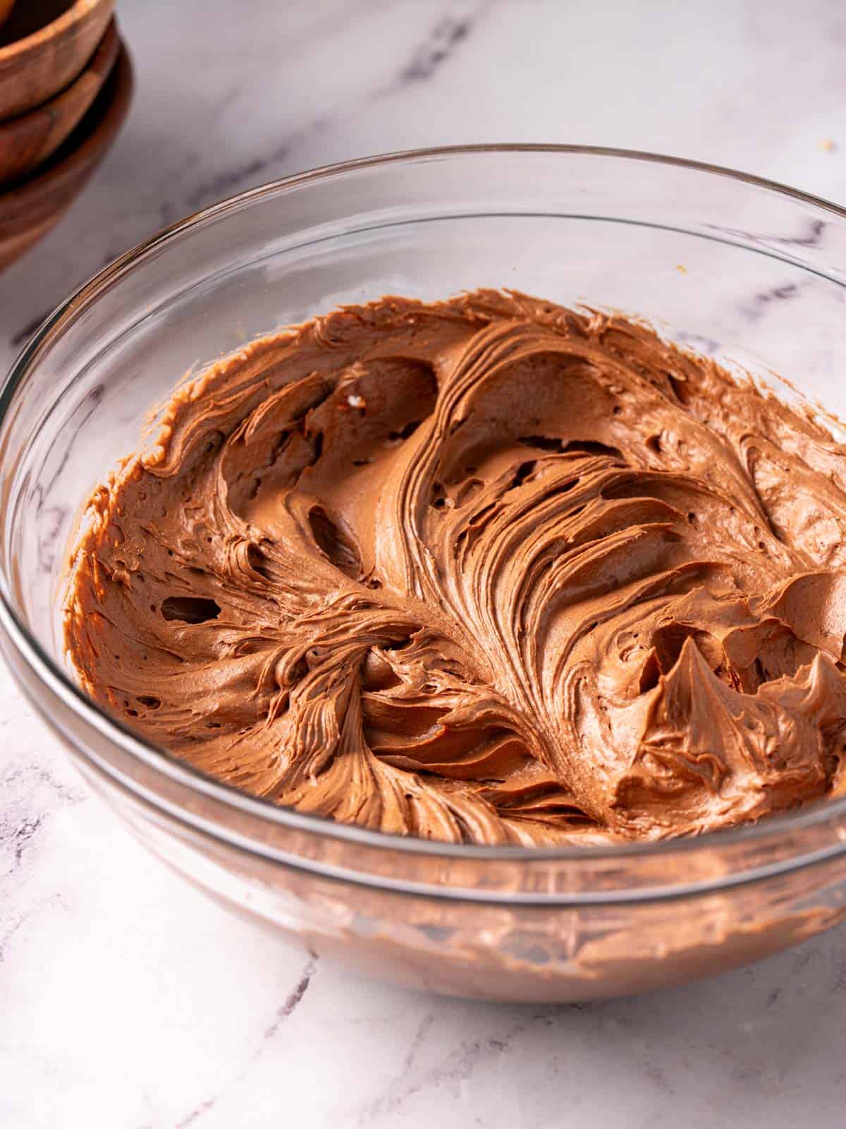 Chocolate frosting made with sour cream in a bowl on the counter.