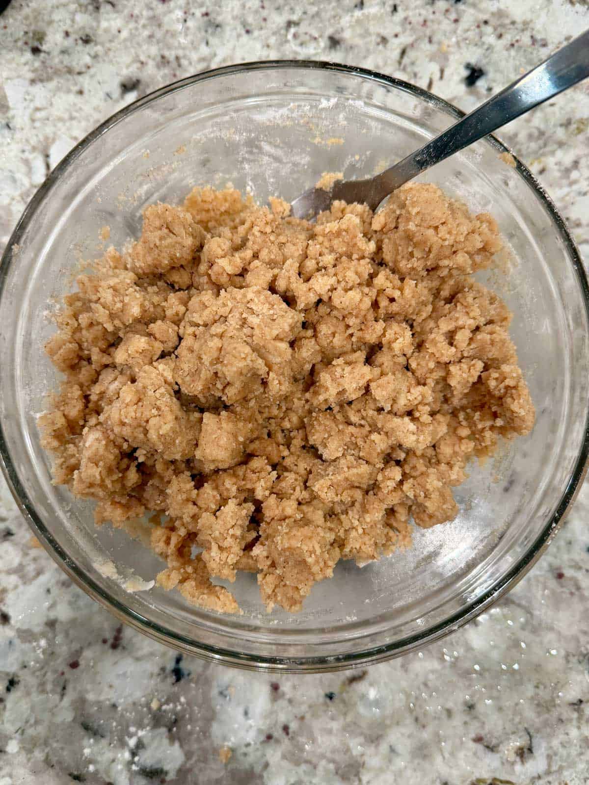 Crumble Streusel topping in a bowl on the counter with a fork in it.