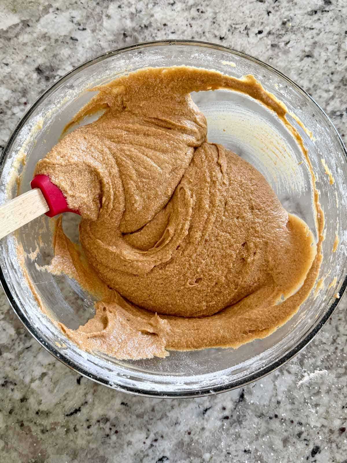 The coffee cake batter after the instant coffee was adding to it in a clear bowl.