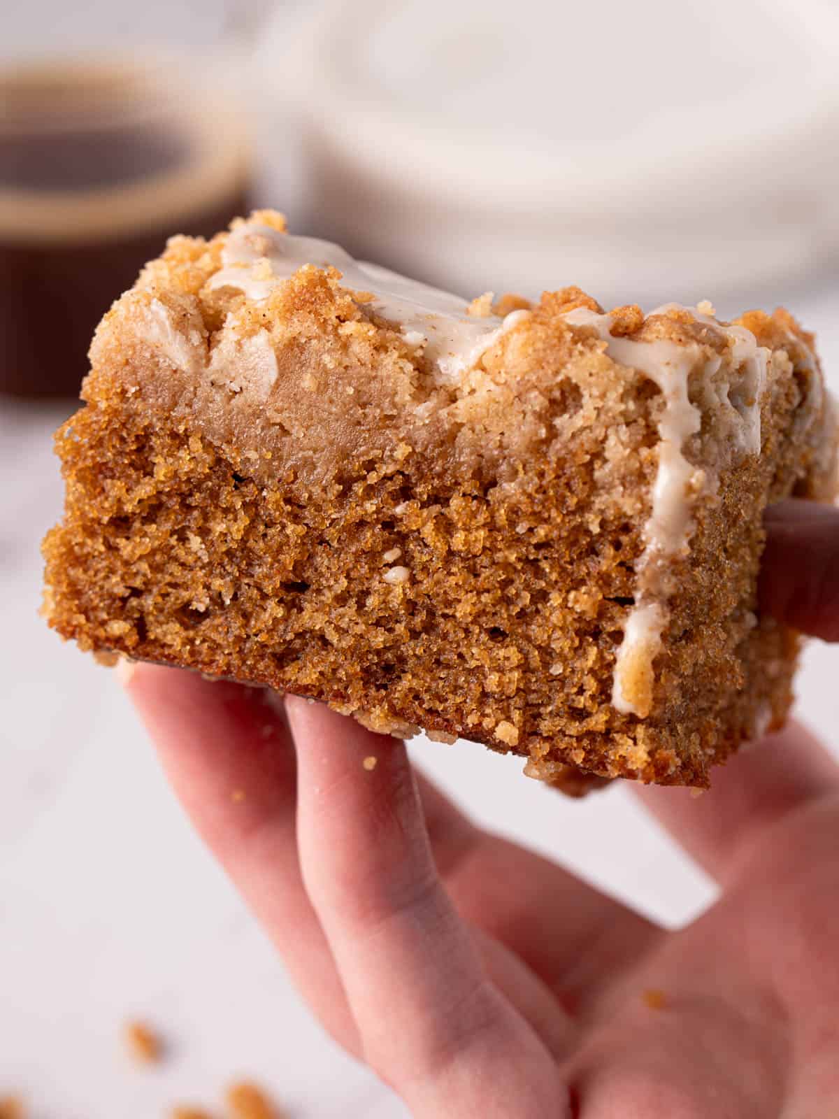 Showing a slice of the cake with the streusel topping being held showing the texture.