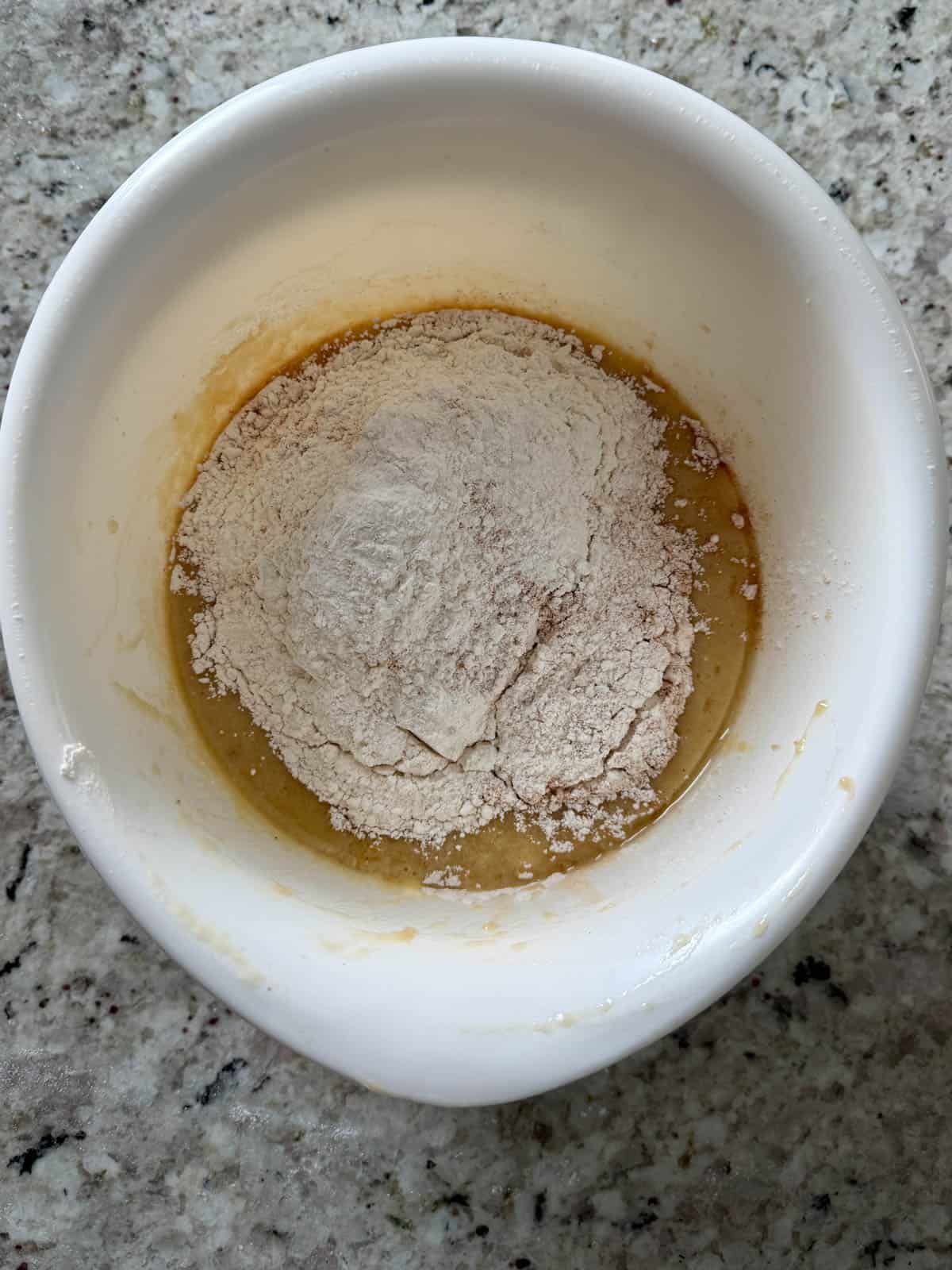 All purpose flour, cinnamon, all spice, nutmeg, and ginger, and baking soda, and salt being added to the bowl.