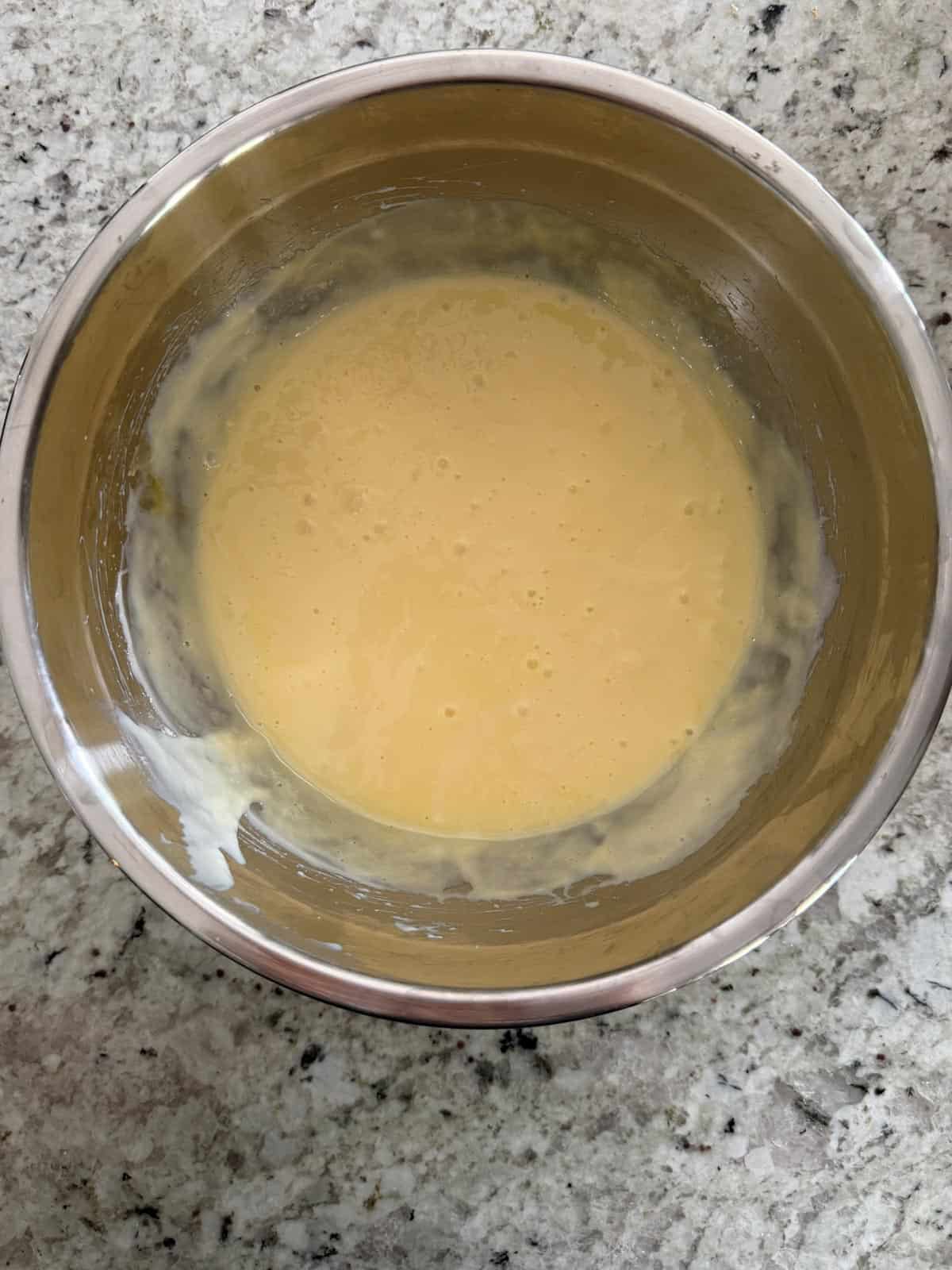 Egg yolks added to the lime juice mixture in a bowl on the counter.