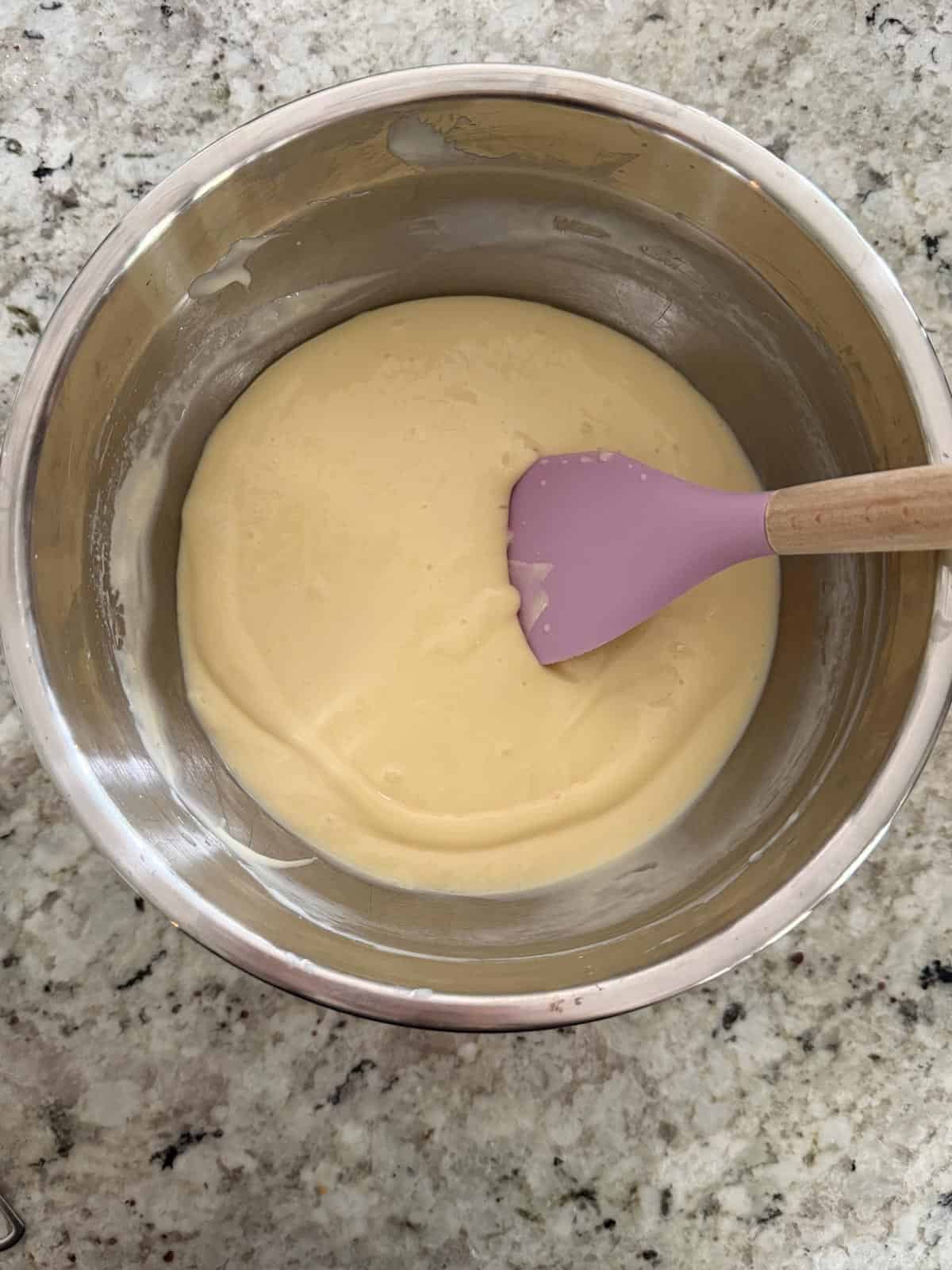 The finished lime cheesecake filling in a bowl with a spatula.