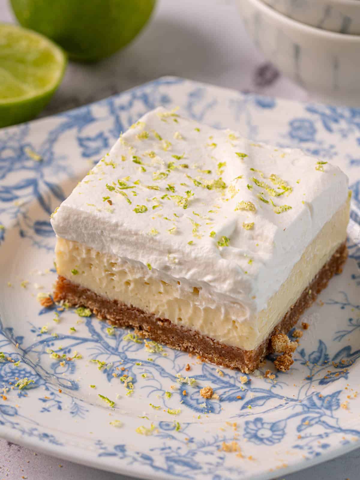 Ginger and lime cheesecake on a plate with lime zest.