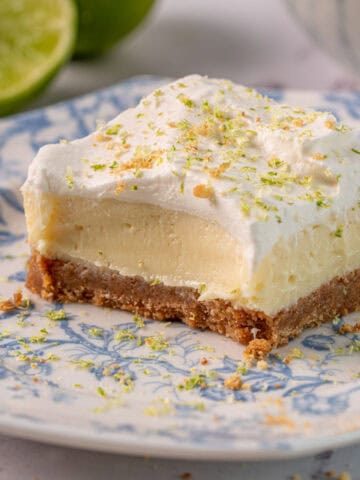 Lime and ginger cheesecake on a plate showing the creamy texture and ginger crust.
