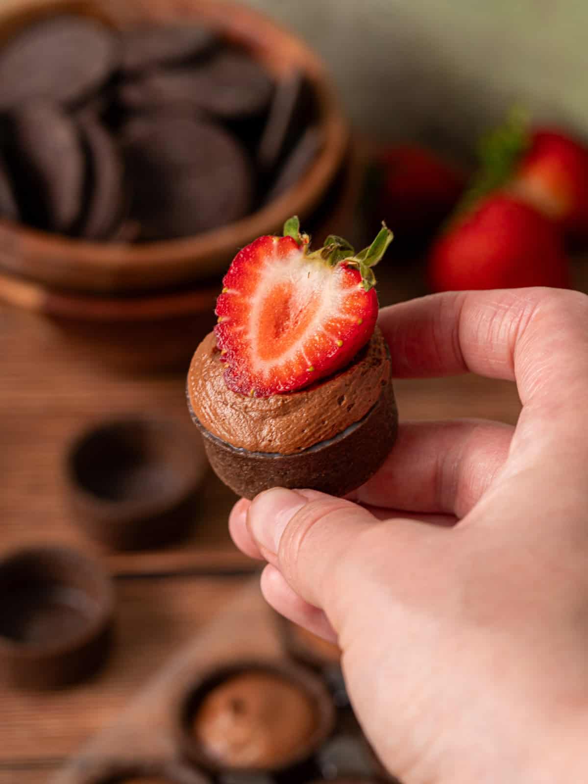 A filled tart shell with chocolate ganache mousse and strawberry on top.