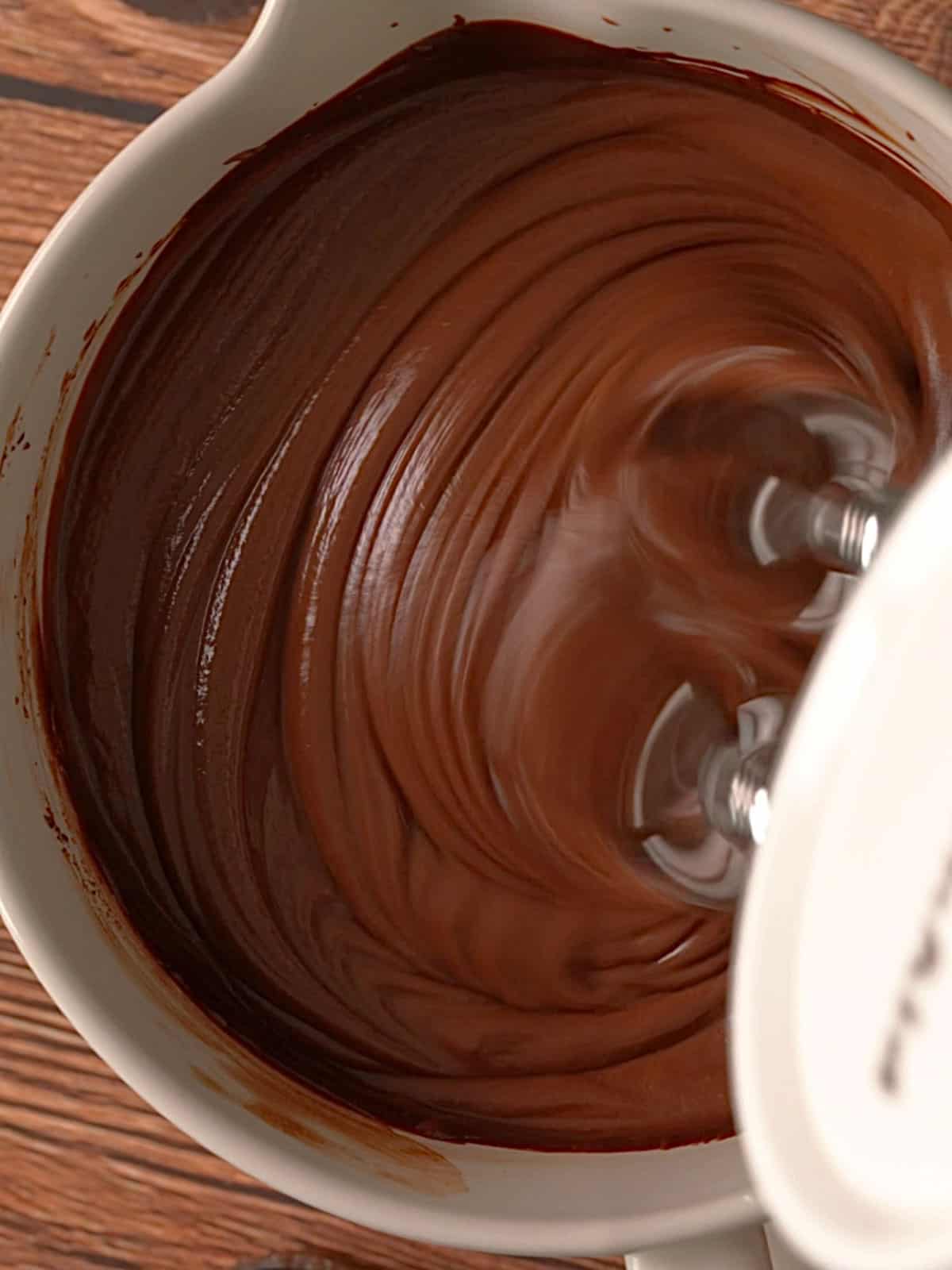 Blending the chocolate ganache and the mascarpone in a mixing bowl.