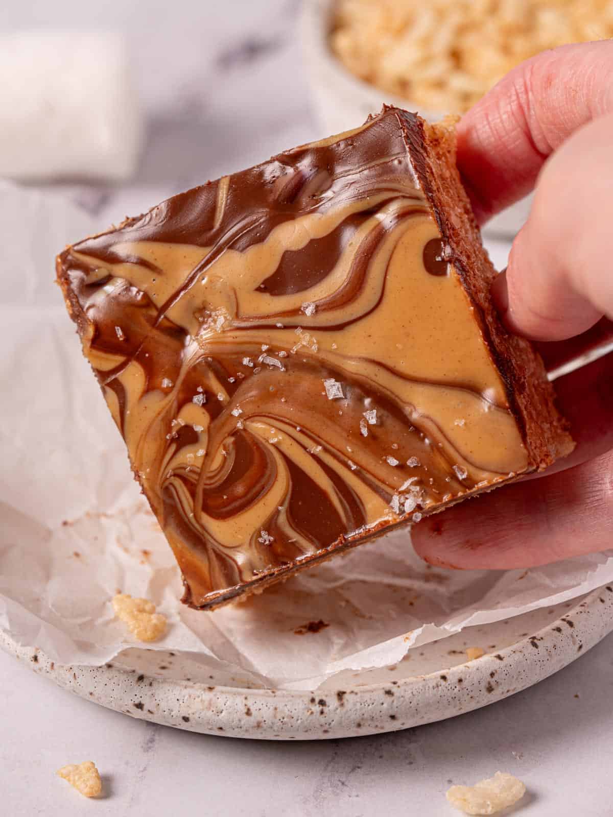 Peanut butter chocolate rice krispie bars with chocolate topping and a swirl.