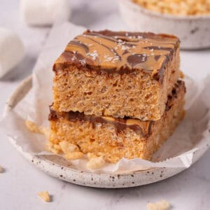 Chocolate and peanut butter rice krispie treats stacked with chocolate peanut butter topping.