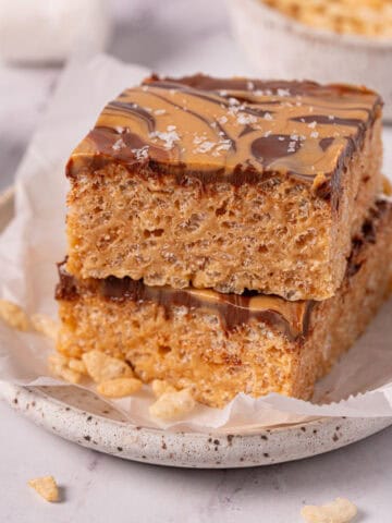 Chocolate and peanut butter rice krispie treats stacked with chocolate peanut butter topping.
