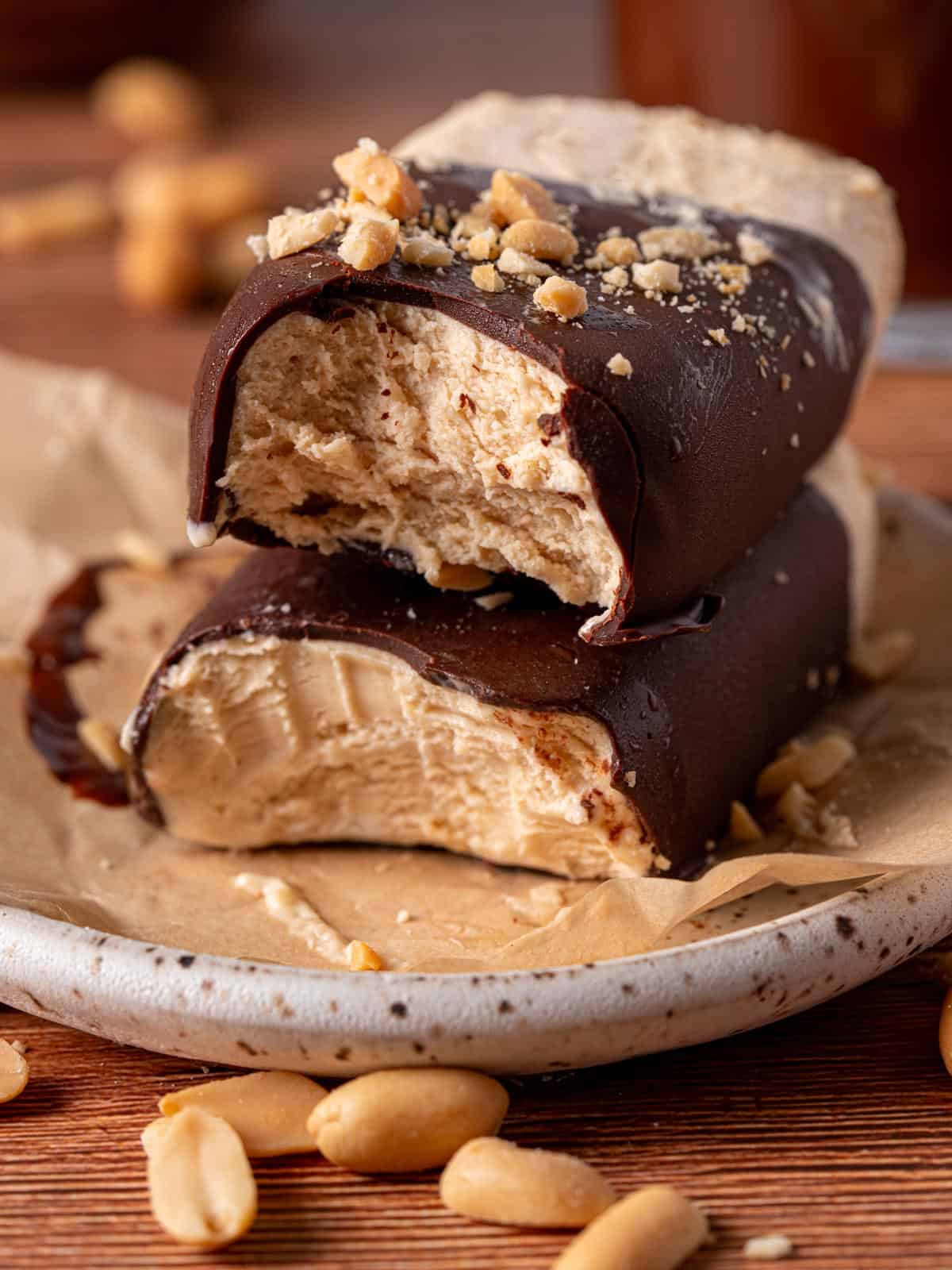 Homemade chocolate peanut butter ice cream bars stacked on top of each other.