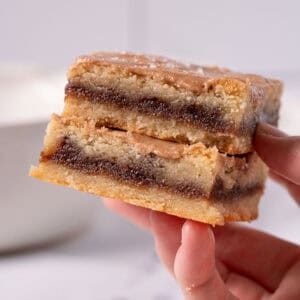 Brown sugar bars being held up showing the cinnamon brown sugar filling and the cinnamon glaze.