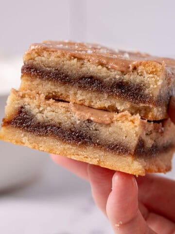 Brown sugar bars being held up showing the cinnamon brown sugar filling and the cinnamon glaze.