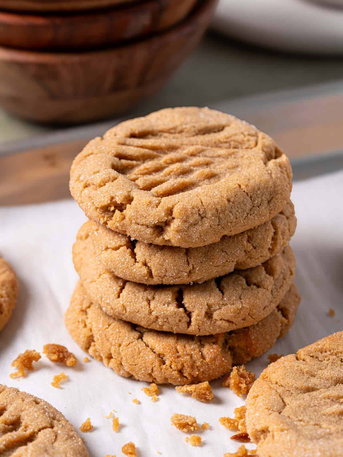 A stack of soft peanut butter cookies on a baking sheet.