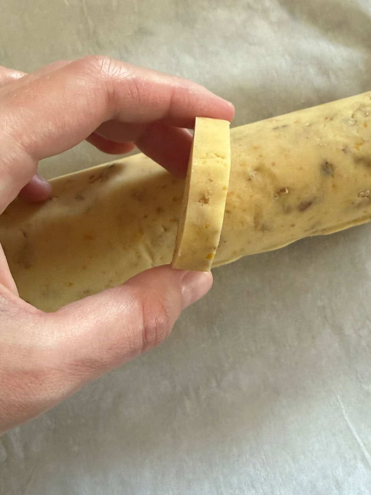 Slicing the shortbread cookie dough into discs before baking.