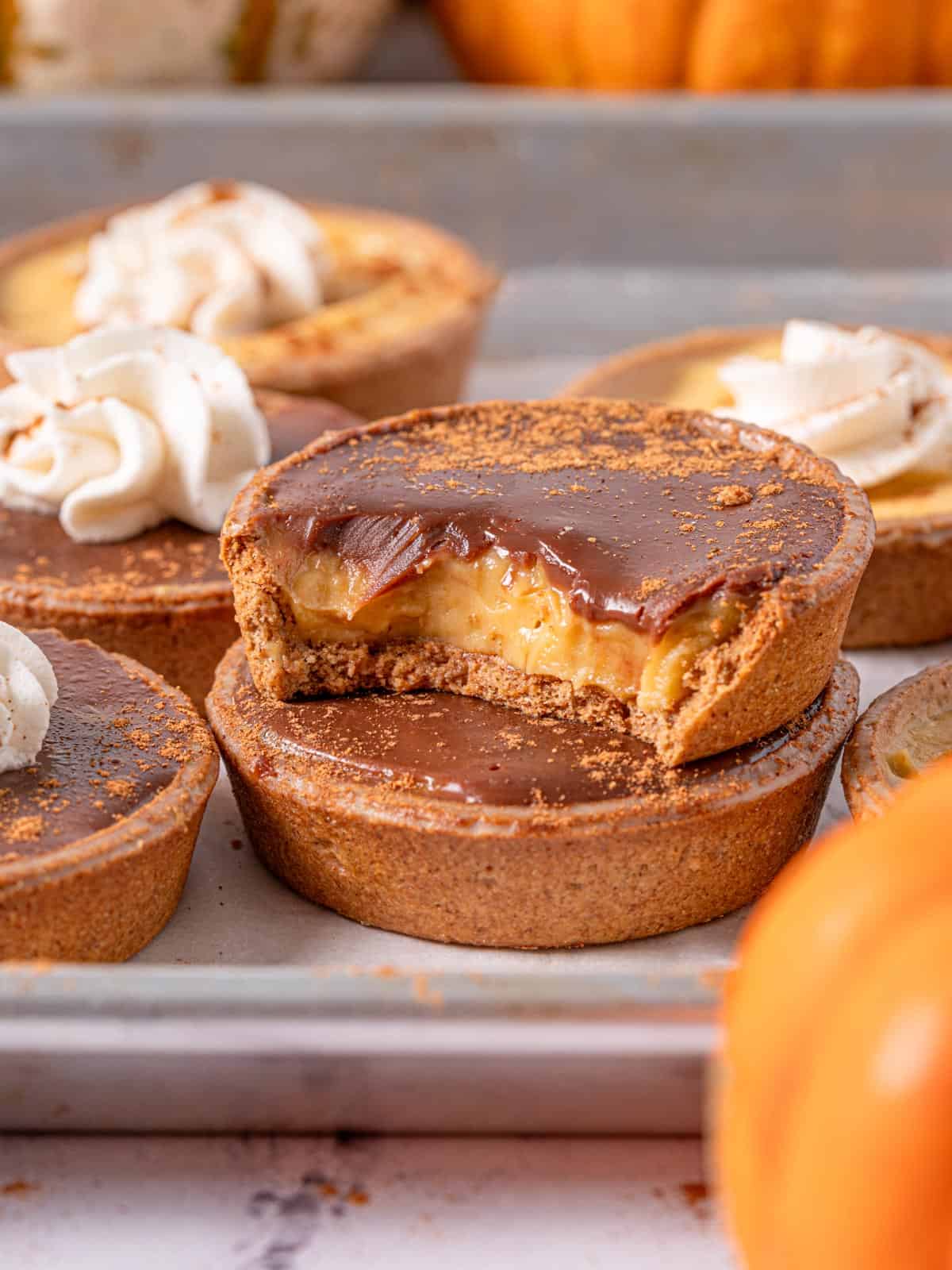 A tart with a bite taken out showing the creamy pumpkin pastry cream.